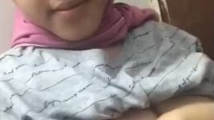 Young woman reveals her curves in a hijab tank top