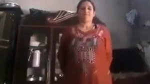 A Pakistani woman removes her clothing to unveil her large breasts and genitalia