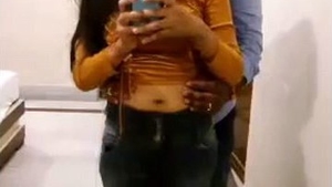 A loving couple explores each other's bodies in front of a hotel mirror